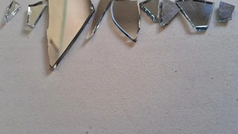 Sharp broken mirror shards scattered on a clean white textured surface Stock Photos