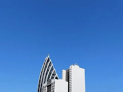 Sharp building tip against cloudless blue sky Stock Photos