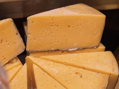 Sharp Cheddar Cheese Blocks Displayed at Market Stock Photos