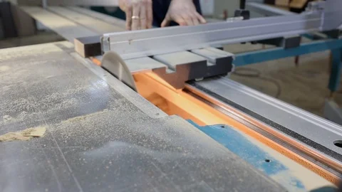 Sharp circular saw blade rotates on machine, carpenter cuts wooden board, man Stock Footage 124923326