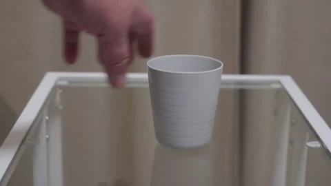 Sharp Clack of Finality as Hand Sets Empty White Plastic Cup on Glass Stock Footage 321267453