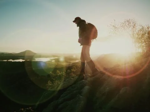 Sharp cliff edge with man watching over misty land Stock Photos