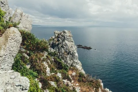 Sharp cliffs hang over the ocean, Dramatic marine background Stock Photos