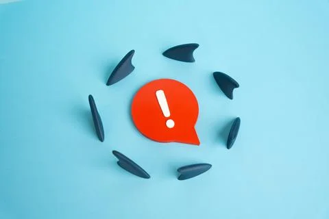 Sharp comment surrounded by shark fins. Harsh criticism and risk of backlash. Stock Photos