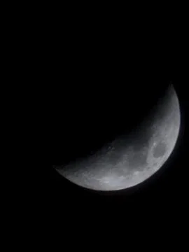 Sharp Crescent Moon Against Black Night Sky Stock Photos