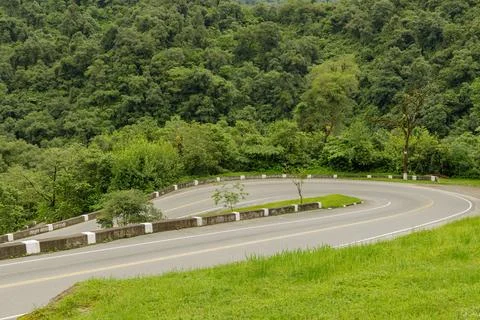 Sharp curve on a mountain route surrounded by vegetation. 写真素材