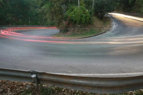 Sharp curve road with car light line Foto stock