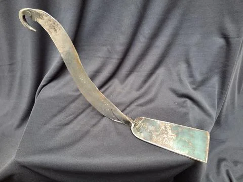 Sharp, curved sickle with sturdy handle, ideal for harvesting crops Stock Photos