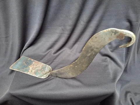 Sharp, curved sickle with sturdy handle, ideal for harvesting crops 스톡 사진