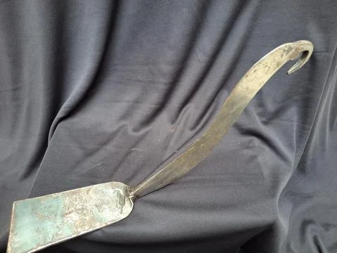 Sharp, curved sickle with sturdy handle, ideal for harvesting crops Stock Photos