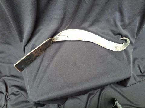 Sharp, curved sickle with sturdy handle, ideal for harvesting crops Stock Photos