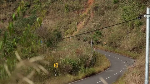 Sharp Curving Hill Road With Warning Signs in Countryside Stock Footage 329839722