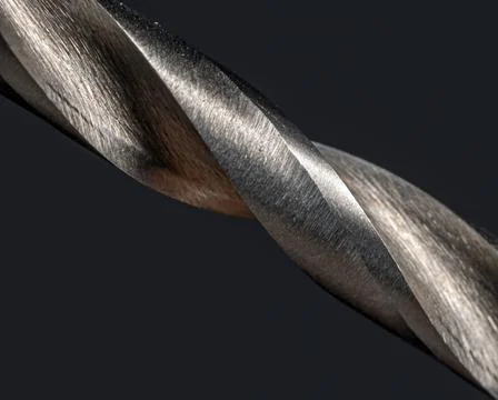 Sharp cuts of screw-threads on a metal drill, macro view. Stock Photos