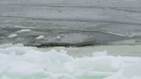 Sharp edge of ice shards is bordered by flowing water of cold arctic sea Video stock 150062520