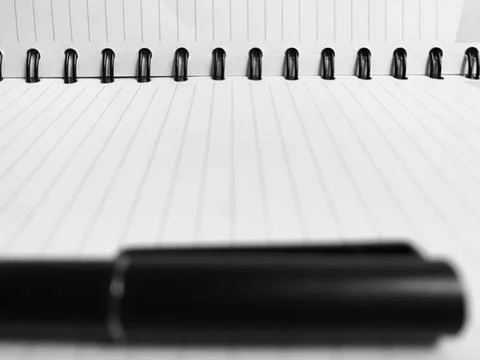 Sharp Focus Spiral Notebook Binding Blurred Pen Foreground Black and White Macro Stock Photos