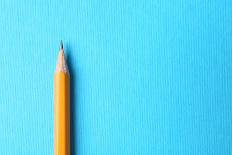 Sharp graphite pencil on light blue background, top view. Space for text Stock Photos