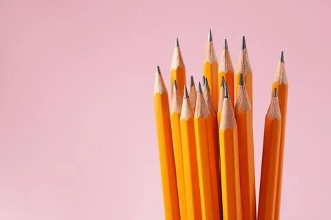 Sharp graphite pencils on pink background, closeup. Space for text Stock Photos