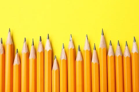 Sharp graphite pencils on yellow background, flat lay Stock Photos