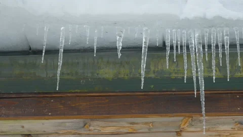 Sharp ice hanging on the side of the roof Stock Footage 148800663