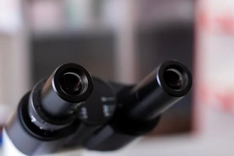 Sharp image focusing on microscope eyepieces with softly obscured lab Stock Photos