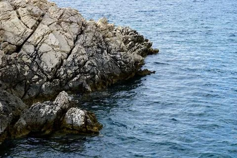 A sharp, jagged big rock submerged in seawater Stock Photos