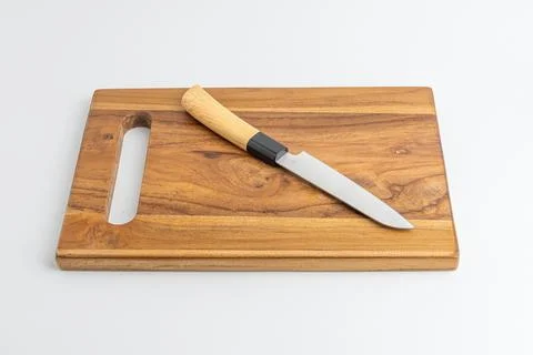 Sharp kitchen chef knife resting on wooden cutting board isolated on white .. Stock Photos