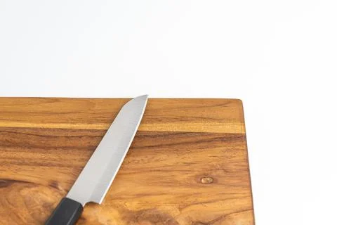 Sharp kitchen chef knife resting on wooden cutting board isolated on white .. Stock Photos