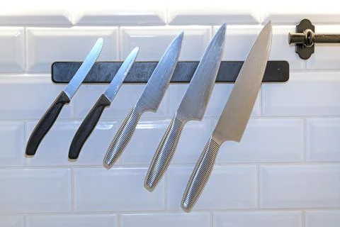 Sharp kitchen knife on black magnetic holder Stock Photos