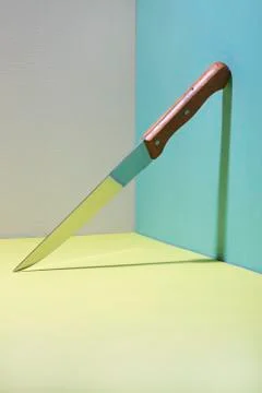 Sharp kitchen knife in the corner on a colored background Foto stock