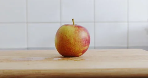 A sharp kitchen knife cuts a ripe apple on a wooden chopping board Stock Footage 205266278