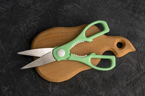 Sharp kitchen scissors on a wooden cutting board in the kitchen Stockfoto's