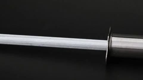 Sharp knife and sharpening stone isolated on black background. Stock Footage 248272872