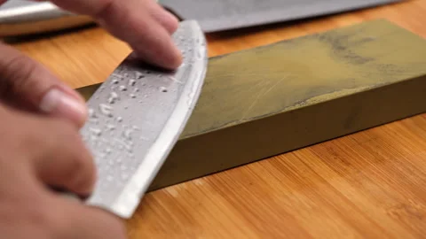 Sharp knife and sharpening stone on a wooden cutting board. Stock Footage 248340541