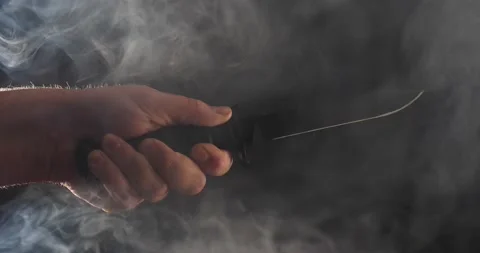Sharp knife being thrust forward isolated on black smoke swirling Stock Footage 205957795