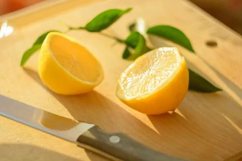 Sharp knife blade and cut lemon in soft focus Stock Photos