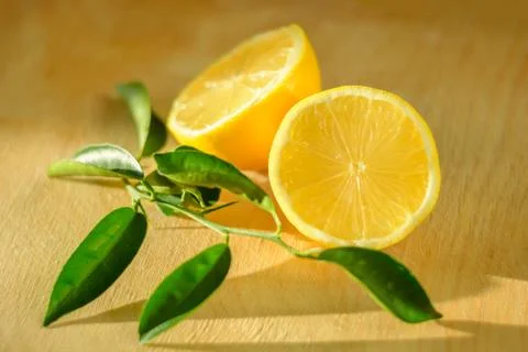 Sharp knife blade and cut lemon in soft focus Stock Photos