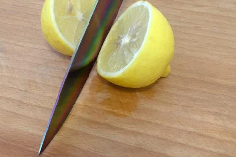 Sharp knife cuts yellow lemon Stock Photos
