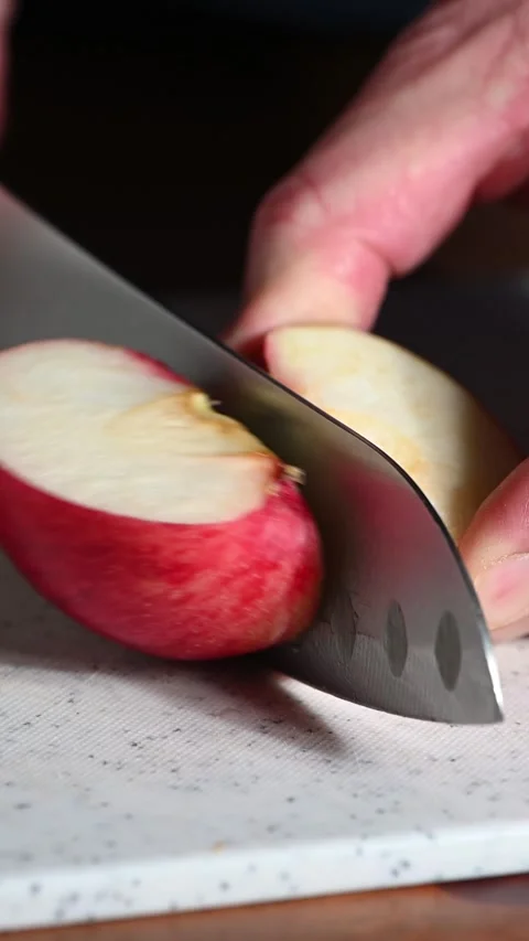 Sharp knife cutting fresh red apple in ultra slow motion Stock Footage 329235333