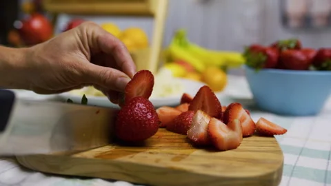 Sharp knife cutting up strawberry on cutting board - slow motion closeup shot Stock Footage 341272638