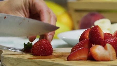 Sharp knife dicing up strawberries on cutting board - closeup shot Stock Footage 341269260