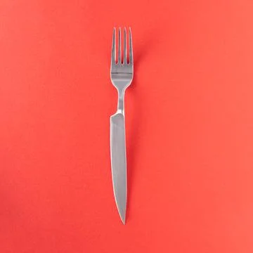 With a sharp knife handle against a red background - creative double blade idea Stock Photos