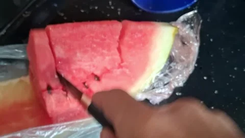 Sharp knife slicing fresh red watermelon in kitchen motion video Stock Footage 339247444