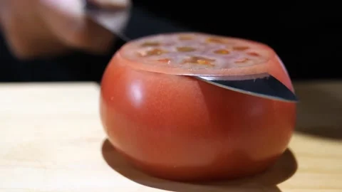 Sharp Knife Slicing a Ripe Tomato on a Wooden Board Stock Footage 340900212