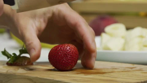 Sharp knife slicing through delicious strawberry on cutting board in slow motion Stock Footage 341271983
