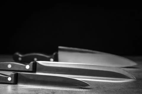 Sharp knives on table against dark background. Space for text Stock Photos