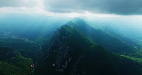Sharp Mountain Edge Sun Covered In Clouds Sun Rays Shining Aerial Orbit Shot Video stock 289411864