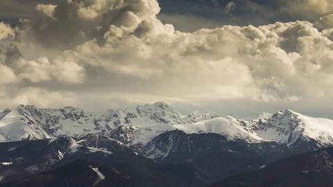 Sharp mountain peaks covered with snow in clouds time lapse Video stock 83558998