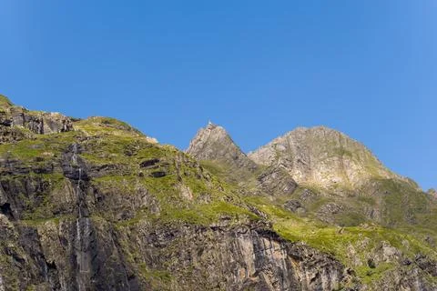 Sharp mountain summit and green slopes, Gavarnie Stock Photos