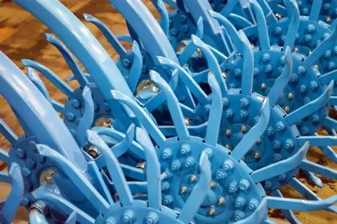 Sharp, painted teeth of a rotary harrow of a soil-processing unit Stock Photos