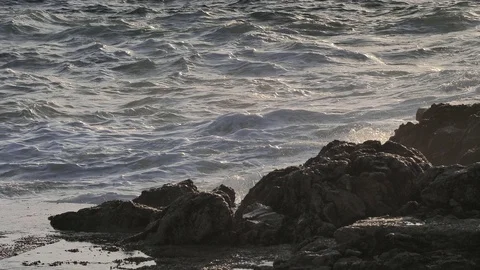 Sharp peace of rocky land ends in sea. Wavy foamy salt water hits the land again Stock Footage 125256269